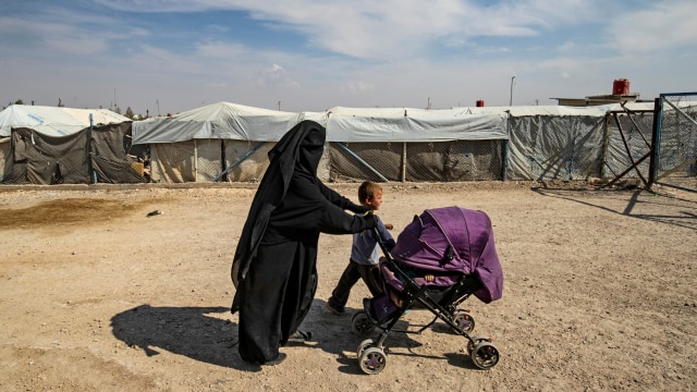 Seorang wanita bersama anaknya di kamp al-Hol yang ditempati oleh keluarga pejuang Negara Islam (IS) di Suriah pada 17 Oktober 2019. Foto: AFP/Delil SOULEIMAN