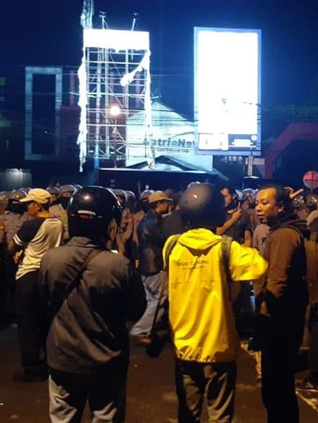 Polisi berjaga di lokasi bentrokan ojek online dan debt collector di Jalan Babarsari, Sleman.  Foto: Arfiansyah Panji Purnadaru/kumparan 