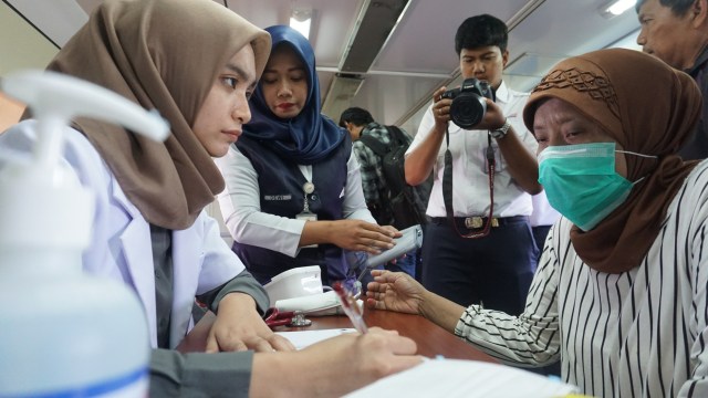Dokter memeriksa suhu badan penumpang saat sosialisasi pencegahan corona di Stasiun Depok, Jumat (6/3). Foto: Nugroho Sejati/kumparan