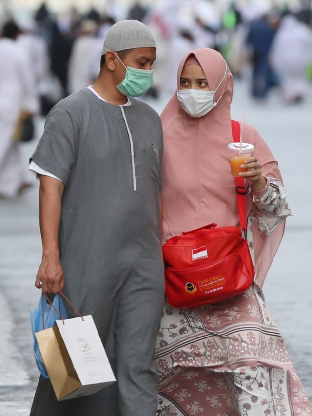 Jemaah mengenakan masker saat berjalan di Masjidil Haram di kota suci Makkah Arab Saudi. Foto: AFP/ABDEL GHANI BASHIR