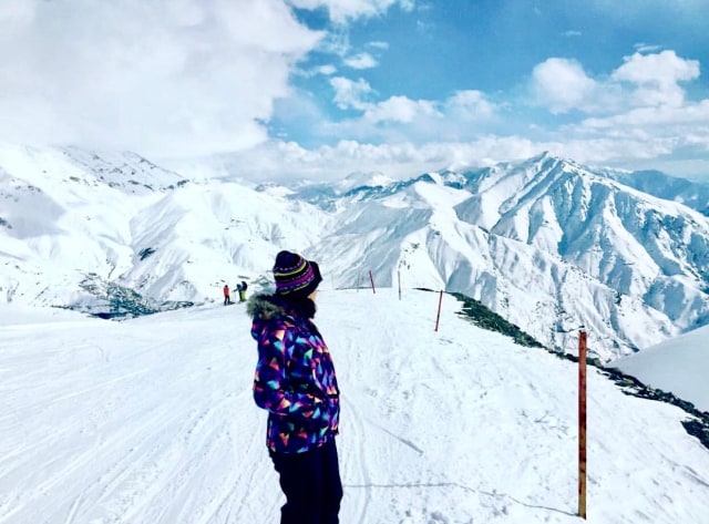 Seorang pemain ski menikmati pemandangan pegunungan bersalju di Resor Ski Darbansar. Sumber: Manzar Veisi