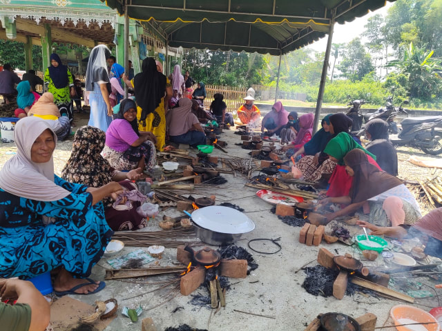 Para perempuan di Gampong Lameue Lueng, Kabupaten Pidie, Aceh, tengah memasak apam (toet apam), yang dilaksanakan setahun sekali di bulan Rajab, Minggu (8/3/2020). Foto: Gade Ridwan untuk acehkini