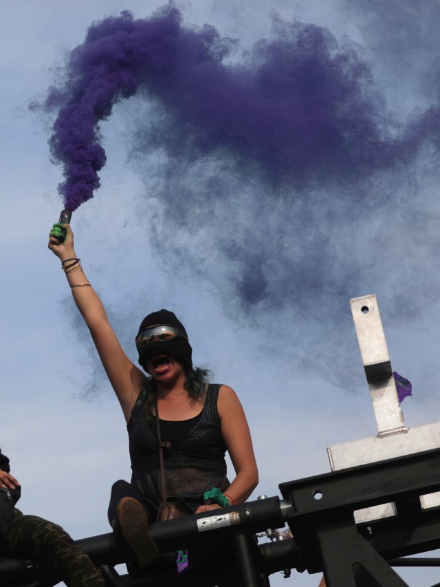 Seorang peserta Hari Perempuan Internasional di Meksiko menyalakan flair. Foto: REUTERS/Raquel Cunha