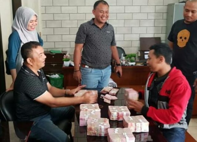 Personel Polda Aceh menghitung uang yang diserahkan oleh seorang pria karyawan sebuah perusahaan swasta di Aceh yang menyerahkan diri setelah diduga mencuri uang kantor senilai Rp 1 miliar lebih. Foto: Dok. Polda Aceh