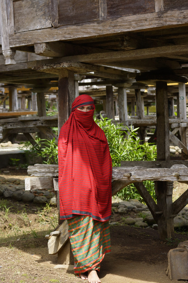 Wanita menggunakan rimpu mpida yaitu pakaian khas dari kain tenun tradisional nggoli yang dililitkan ke kepala seperti burka dan bawahannya sanggetu seperti rok saat di kawasan Uma Lengge Maria. Foto: Tpal12