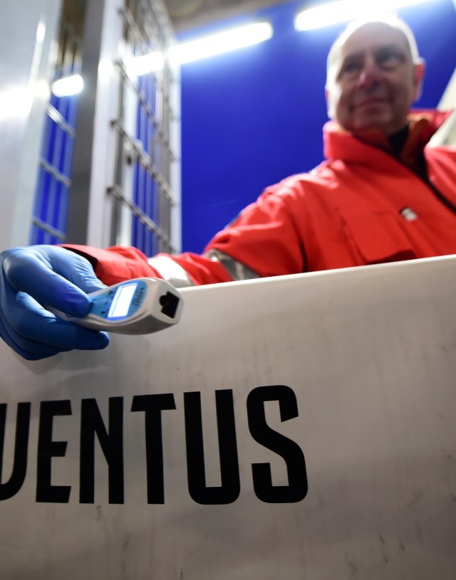 Seorang petugas di Allianz Stadium, Torino, memegang thermal scanner (pemindai suhu tubuh). Foto: Reuters/Massimo Pinca