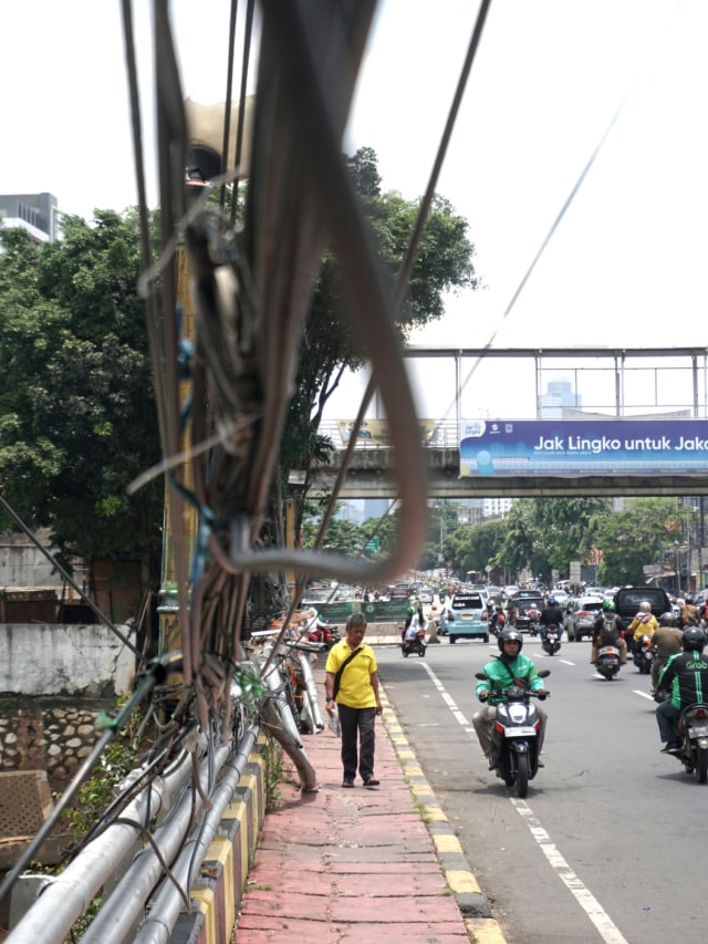 Suasana di sekitar lokasi kabel listrik yang menjuntai di trotoar di kawasan Bukit Duri, Jakarta Timur (10/3). Foto: Iqbal Firdaus/kumparan