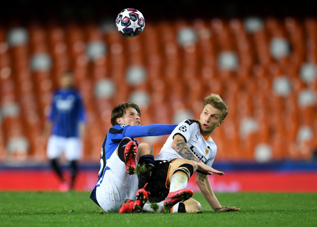 Aksi pemain Atalanta, Hans Hateboer (kanan) dan pemain Valencia, Daniel Wass, Rabu (11/3). Foto: UEFA Pool/Handout via REUTERS