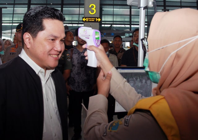Menteri BUMN Erick Thohir melakukan pemeriksaan suhu tubuh di Bandara Soekarno Hatta, Tangerang , Banten, Rabu (11/3).