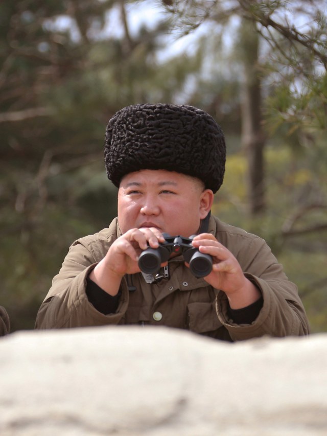 Gaya Pemimpin Tertinggi Korea Utara Kim Jong-Un saat memantau latihan peluncuran rudal di dampingi seorang perwira militer, Senin (9/3). Foto: KCNA via Reuters