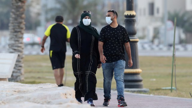 Sejumlah pejalan kaki mengenakan masker di provinsi Qatif, Arab Saudi. Foto: REUTERS