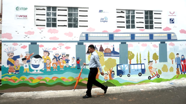 Pejalan kaki melintasi lukisan mural, di Jalan Darul Maarif, Jakarta Selatan, Rabu (12/3). Foto: Iqbal Firdaus/kumparan