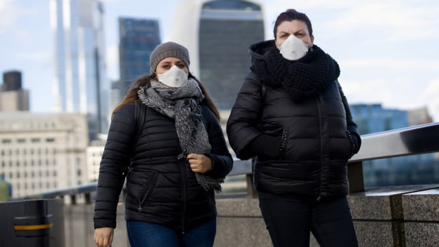 Sejumlah pejalan kaki mengenakan masker saat berjalan di London, Inggris. Foto: AFP/TOLGA AKMEN
