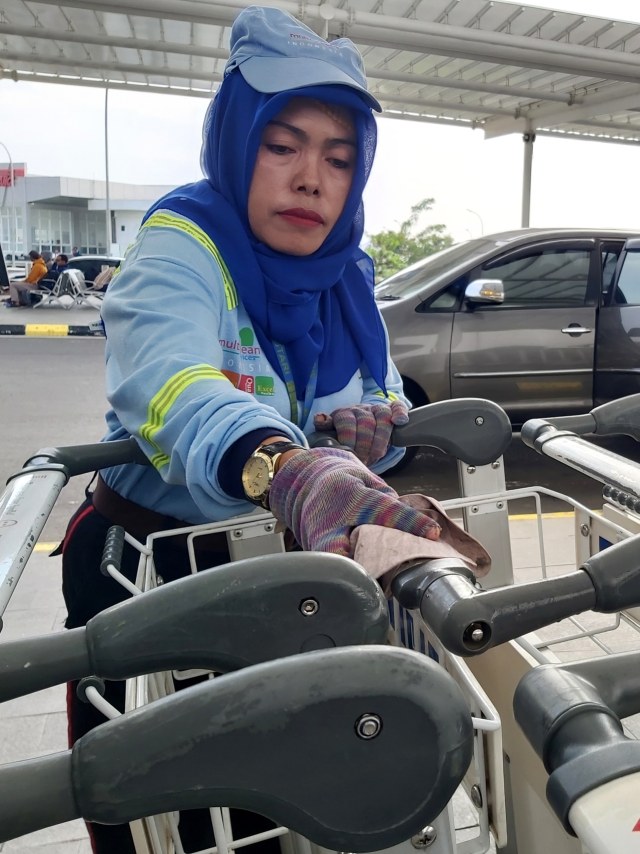 Petugas membersihkan troli di areal Bandara Internasional Jendral Ahmad Yani Semarang. Foto: Afiati Tsalitsati/kumparan