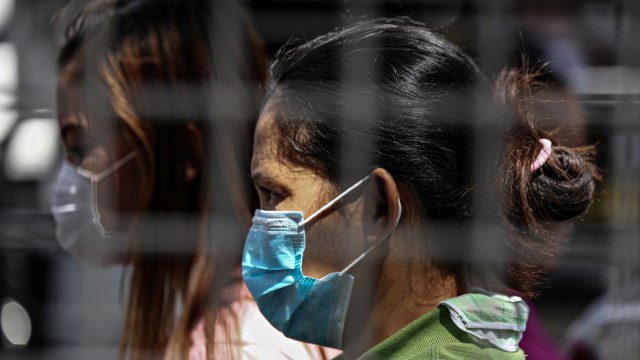 Salah satu penumpang mengenakan masker saat menunggu di Terminal Bus Pusat Araneta di Cubao di Manila, Filipina, Jum'at (13/3).  Foto: AFP/MARIA TAN