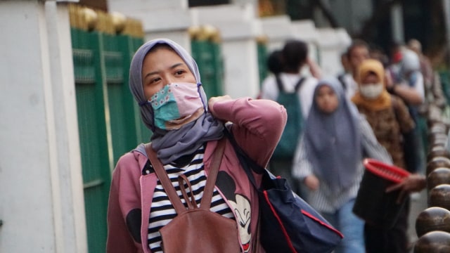 Warga pakai masker beraktivitas di Kawasan Cikini, Jakarta, Jumat (13/3). Foto: Jamal Ramadhan/kumparan