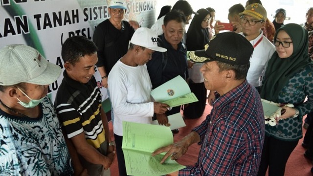 Wali Kota Palu Hidayat saat menyerahkan sertifikat tanah kepada warga Kota Palu, pada Sabtu (14/3). Foto: Humas Pemkot Palu