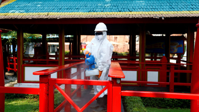 Petugas menyemprotkan cairan disinfektan di sekitar wahana permainan di Dufan, Taman Impian Jaya Ancol, Jakarta, Sabtu (14/3). Foto: REUTERS/Ajeng Dinar Ulfiana