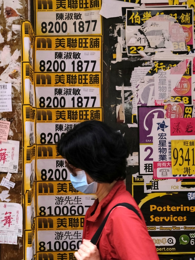 Warga menggunakan masker berjalan di Mongkok, Hong Kong. Foto: REUTERS / Tyrone Siu