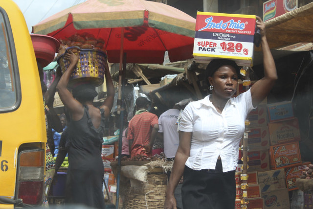 Seorang perempuan di Afrika mengangkut satu kardus Indomie. Sumber: flickr/Juju films