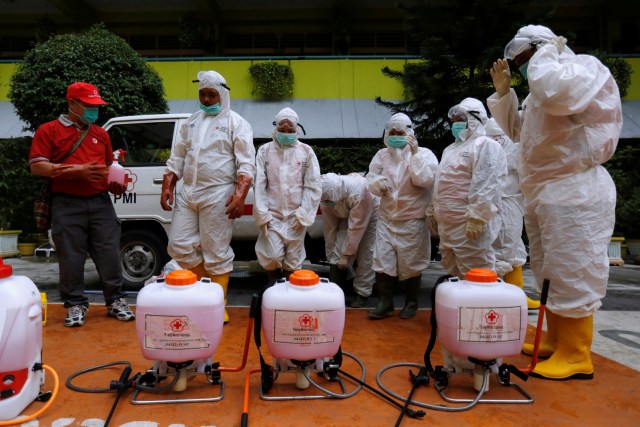 Relawan dari PMI bersiap untuk menyemprotkan disinfektan di sekolah yang ditutup di Jakarta, Senin (16/3). Foto: REUTERS/Willy Kurniawan