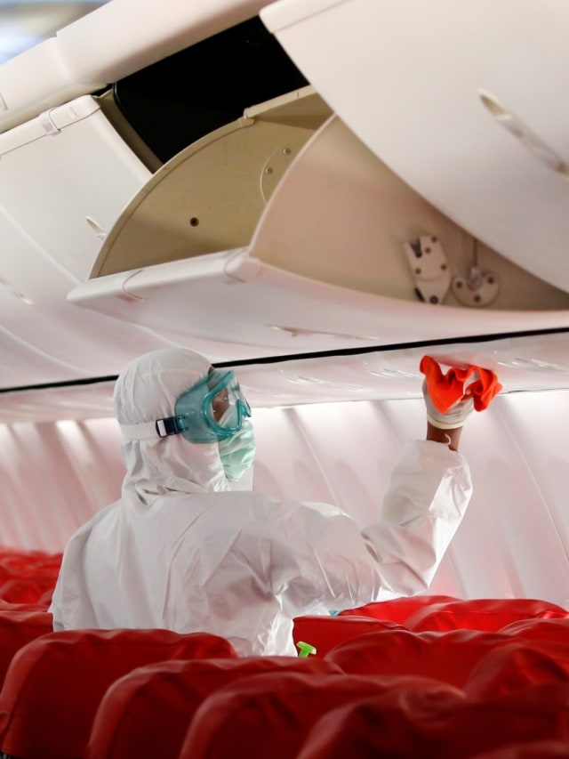 Seorang petugas membersihkan kabin pesawat Boeing 737-800 Lion Air dengan disinfektan di Bandara Internasional Soekarno-Hatta, Selasa (17/3). Foto: REUTERS/Willy Kurniawan