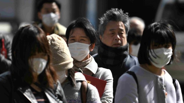 Warga menggunakan masker saat beraktivitas untuk menghindari virus corona. Foto: AFP/PHILIP FONG