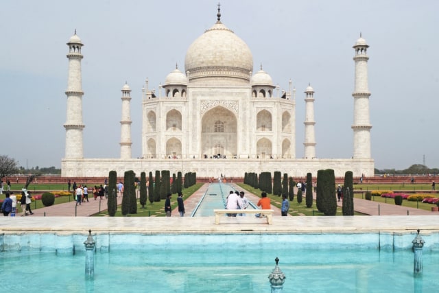 Sejumlah wiasatawan berada di Taj Mahal yang bersejarah di Agra, India, Senin (16/3). Foto: Pawan Sharma / AFP