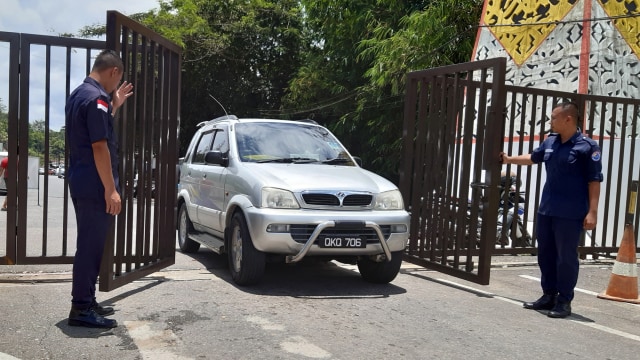 Iluststrasi perbatasan di Sabah. Dua petugas keamanan membuka pintu untuk mobil warga Malaysia melalui Pos Lintas Batas Negara (PLBN) Entikong di Kabupaten Sanggau, Kalimantan Barat. Foto: ANTARA FOTO/Agus Alfian