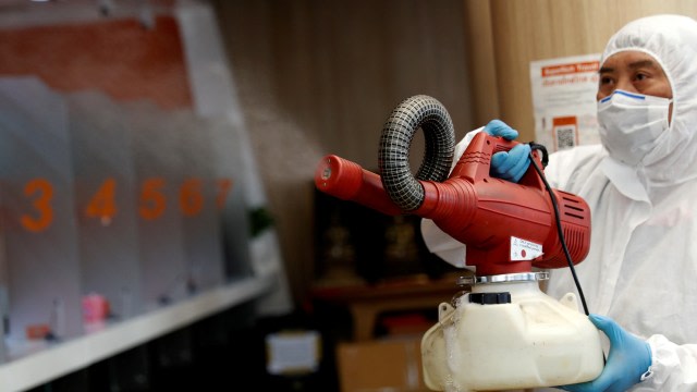 Seorang pria menyemprotkan desinfektan. Foto: REUTERS / Jorge Silva