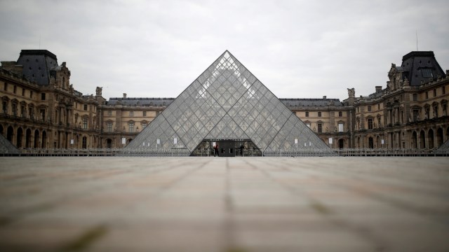 Pandangan menunjukkan daerah sepi di depan piramida kaca museum Louvre di Paris, Prancis, selama wabah virus corona, (18/3). Foto: REUTERS/Christian Hartmann