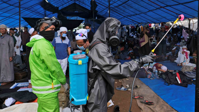 Petugas menyemprotkan disinfektan di lokasi Ijtima ulama Asia di Gowa, Sulawesi Selatan, Kamis, (19/3). Foto: AP Photo/Syaief