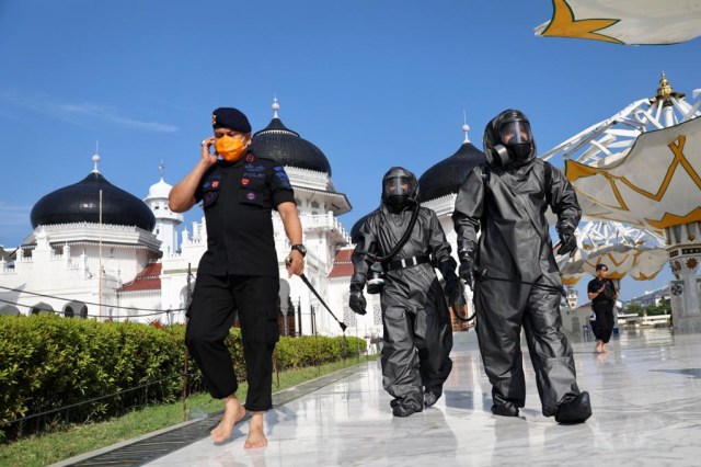 Tim Gegana Polda Aceh menyemprot disinfektan di Masjid Raya Baiturrahma Banda Aceh, jelang Salat Jumat. Foto: Suparta/acehkini 