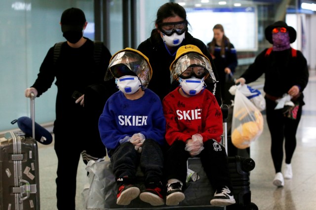 Seorang penumpang menggunakan masker dan kacamata pelindung di Bandara Internasional Hong Kong, Selasa (17/3). Foto: REUTERS/Tyrone Siu
