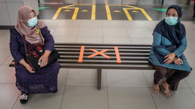 Calon penumpang kereta MRT Jakarta duduk di bangku yang telah diberi stiker panduan jarak antarpenumpang di Stasiun MRT Blok M, Jakarta.  Foto: ANTARA FOTO/Aprillio Akbar