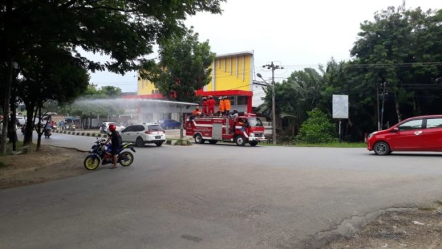 Foto: Damkar Kota Kendari Semprot Ruas Jalan dengan