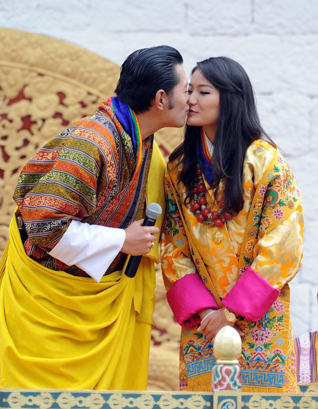 Raja Jigme Khesar Namgyel Wangchuck mencium Ratu Jetsun Pema saat upacara di stadion utama di Thimphu di Bhutan. Foto: Prakash SINGH / AFP