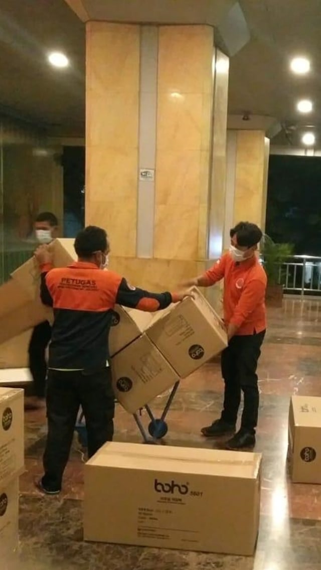 Sejumlah petugas memindah 40 Ribu APD yang tiba di Balikota DKI Jakarta, Senin (23/3). Foto: Instagram / @aniesbaswedan