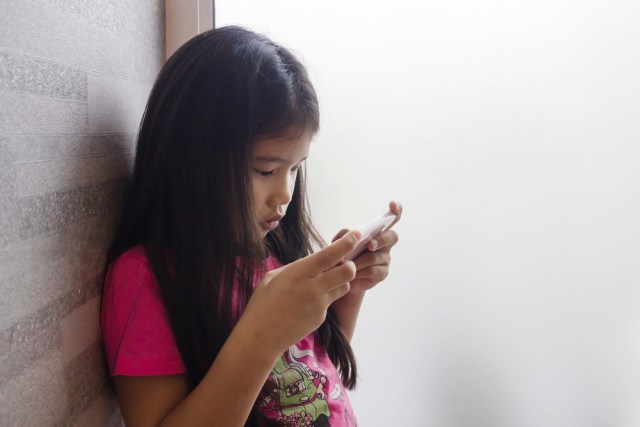 com-Ilustrasi anak yang asik dengan smartphone-nya. Foto: Shutterstock