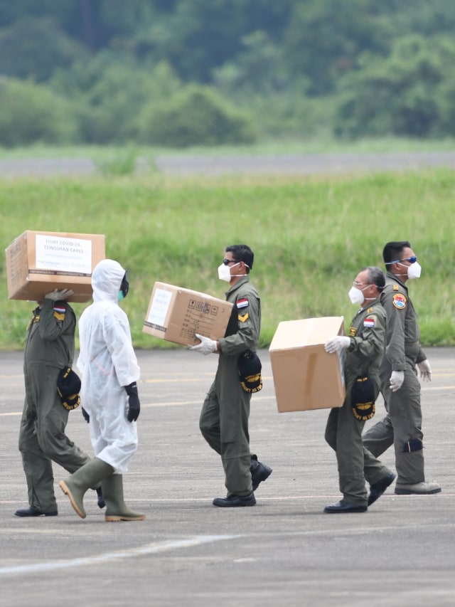 Petugas memindahkan kardus berisi alat kesehatan dari China yang diangkut menggunakan pesawat Hercules C-130 saat tiba di Lanud Halim Perdanakusuma, Jakarta.  Foto: ANTARA FOTO/M Risyal Hidayat