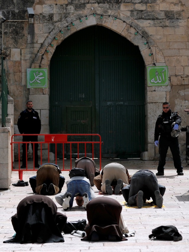 Umat muslim melaksanakan salat di depan Masjid Al-Aqsa yang ditutup antisipasi wabah virus corona di Yerusalem. Foto: REUTERS / Ammar Awad