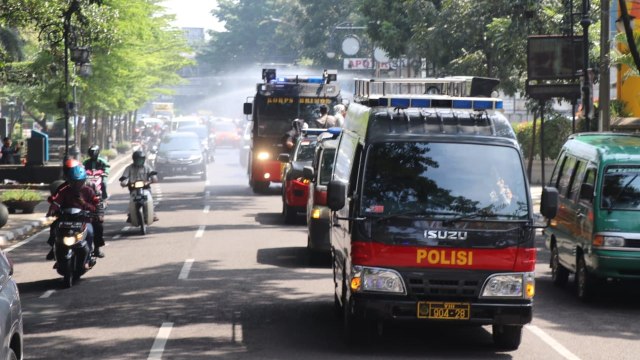 Polrestabes Bandung dan jajaran Brimob Polda Jabar melakukan penyemprotan disinfektan menyusuri sejumlah ruas jalan di Kota Bandung. Foto: Rachmadi Rasyad/kumparan