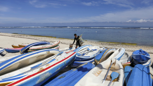 Seorang nelayan bersiap untuk memancing di Pantai Pandawa di Kuta Selatan, Bali, Indonesia, selama ditutup bagi wisatawan akibat wabah corona, Senin (23/3). Foto: REUTERS/Johannes P. Christo