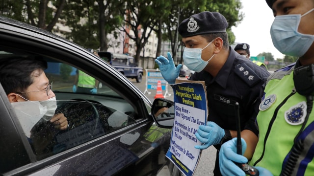 Polisi Malaysia melakukan razia dalam lockdown virus corona. Foto: REUTERS/Lim Huey Teng