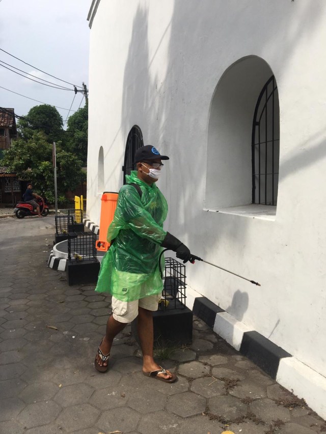 Perangkat desa bersama warga menyemprotkan cairan disinfektan pada fasilitas umum, sekolah, rumah warga guna mencegah penyebaran virus Corona di Yogyakarta. Foto: Dok. Panggungharjo