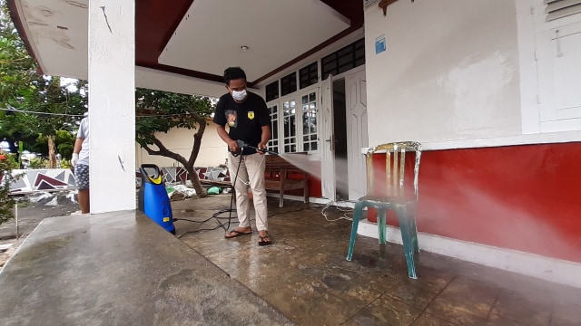 Faisal Opo Anwar, salah satu pengurus Garasi Genta saat menyemprotkan disinfektan di rumah warga di Tanah Tinggi, Ternate, Maluku Utara. Selasa (24/03/2020). Foto: Faris Bobero/cermat