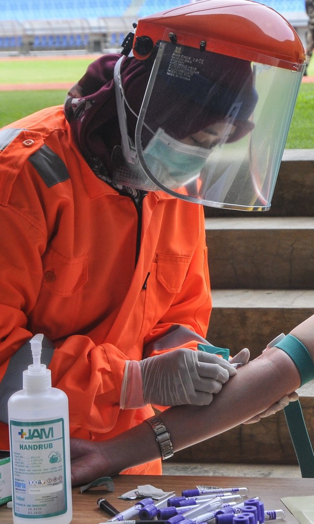 Petugas medis mengecek kesehatannya dengan mengambil sampel darah dengan metode rapid test (pemeriksaan cepat) di Stadion Patriot Candrabhaga, Bekasi Foto: ANTARA FOTO/ Fakhri Hermansyah