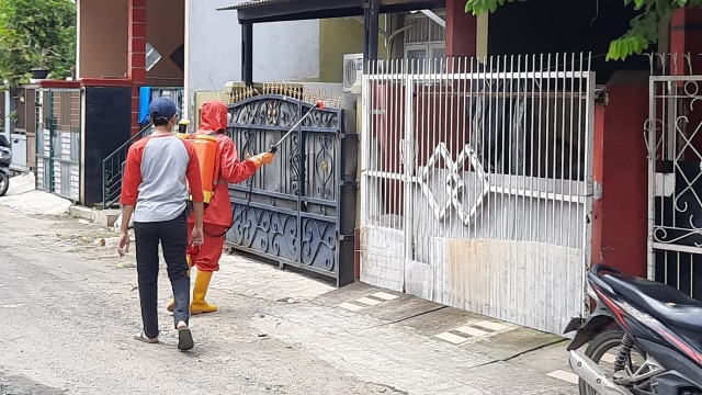Petugas Dinas Kesehatan Kota Tangerang melakukan penyemprotan disinfektan di permukiman warga. Foto: Wendiyanto/ kumparan