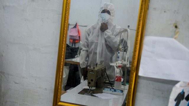 Pekerja menjajal pakaian hazmat atau alat perlindungan diri (APD) tenaga medis di Pusat Industri Kecil, Penggilingan, Jakarta, Kamis (26/3/2020). Foto: ANTARA FOTO/Galih Pradipta