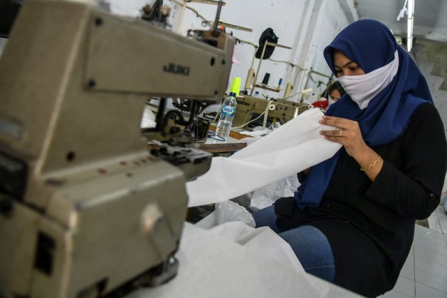 Pekerja menyelesaikan baju hazmat atau alat perlindungan diri (APD) tenaga medis di Pusat Industri Kecil, Penggilingan, Jakarta, Kamis (26/3/2020). Foto: ANTARA FOTO/Galih Pradipta